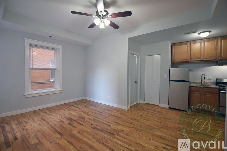 A room with a ceiling fan and wooden flooring.