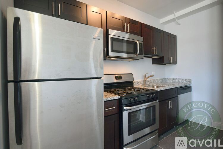 A kitchen with a stainless steel refrigerator, microwave, and oven.