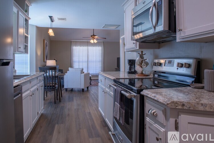 A kitchen with a refrigerator, oven, and microwave.