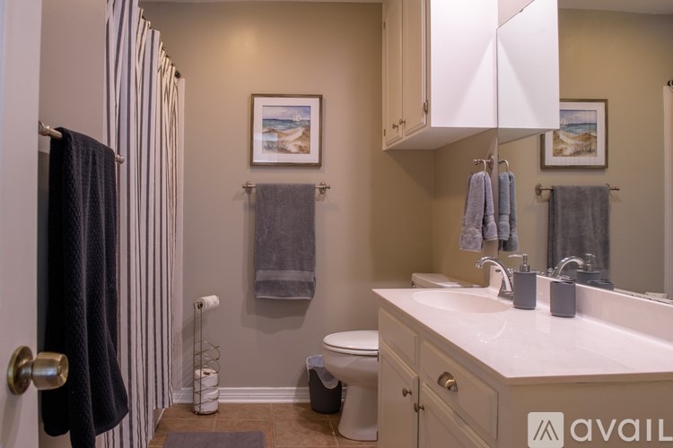 A bathroom with a toilet, sink, and a striped shower curtain.