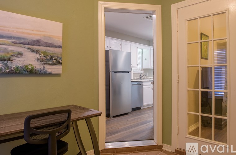 A kitchen with a refrigerator, dishwasher, and oven is visible through an open door.