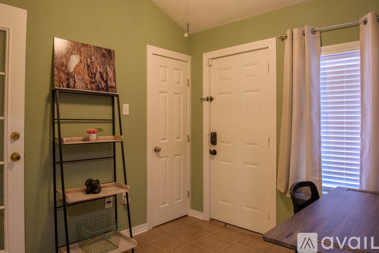 A room with a ladder, a table, and a painting on the wall.