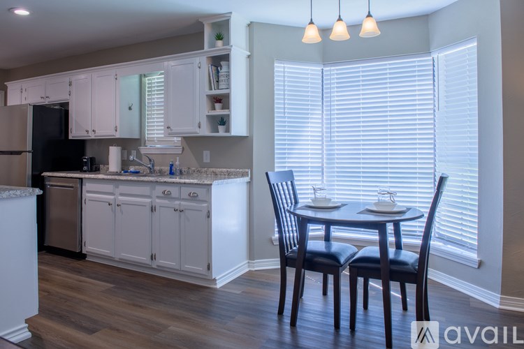 A kitchen with a table and chairs in front of a window.