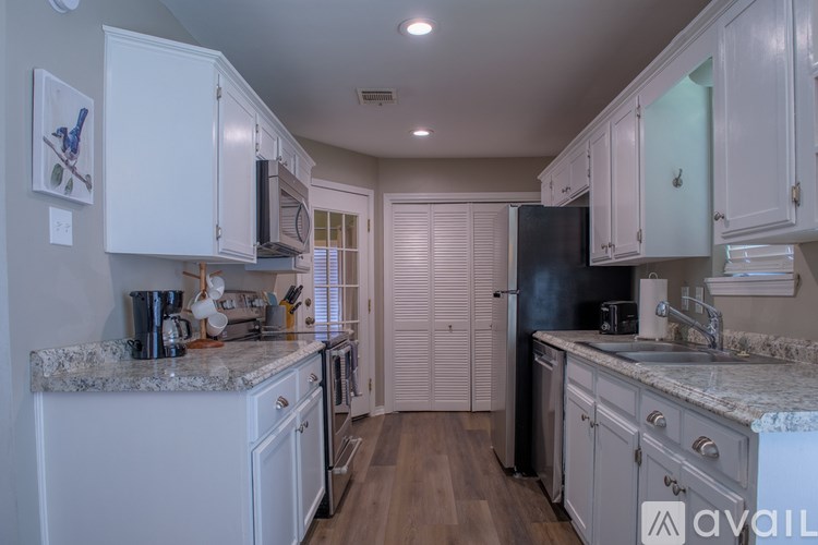 A kitchen with white cabinets and a granite countertop.