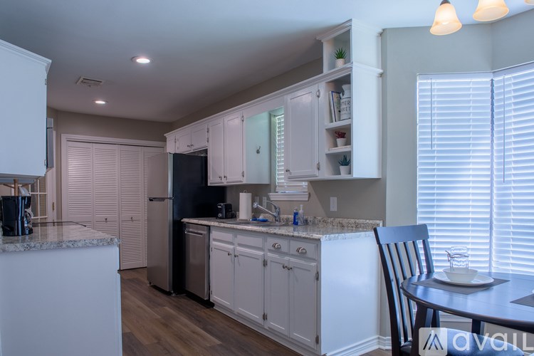 A kitchen with white cabinets and a granite countertop.