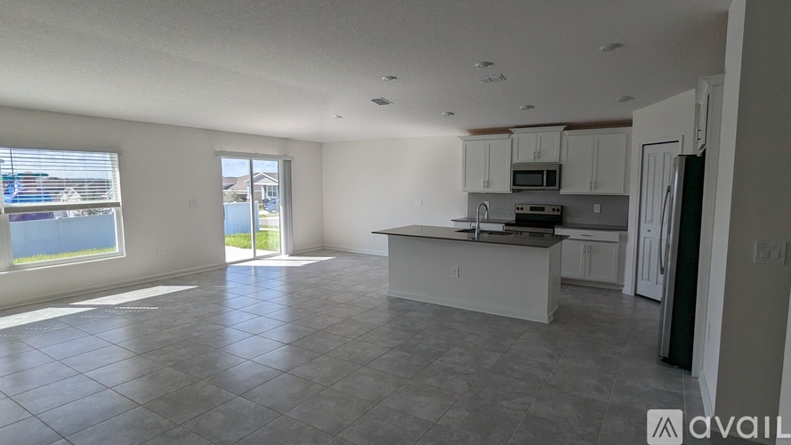 A spacious kitchen with white cabinets and a large island.