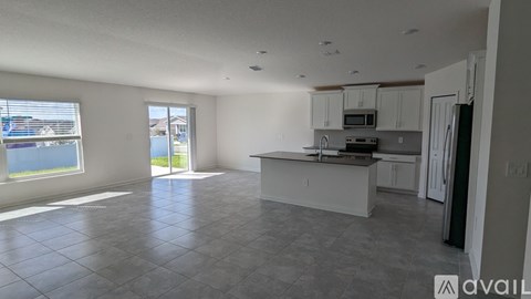 A spacious kitchen with white cabinets and a large island.