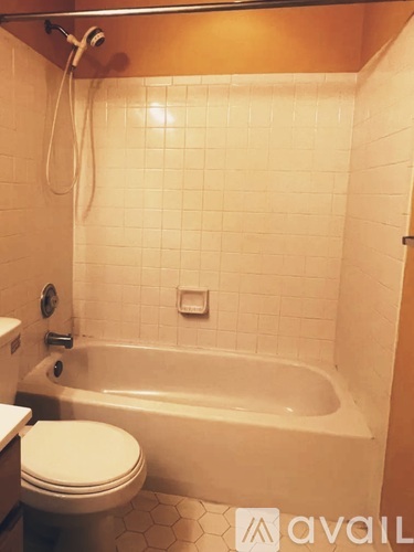 A white toilet is next to a bathtub in a bathroom.