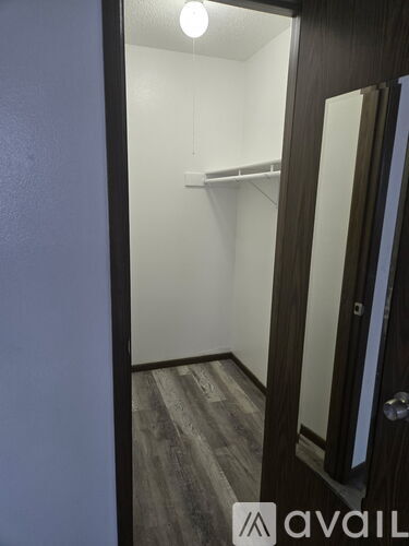 A room with a carpeted floor and a window with blinds.
