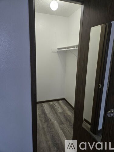 A room with a carpeted floor and a window with blinds.