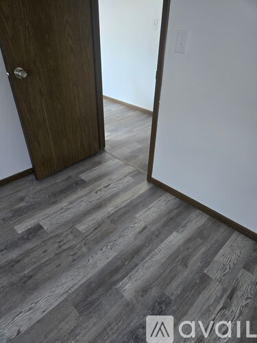 A room with a carpeted floor and a window with a white frame.