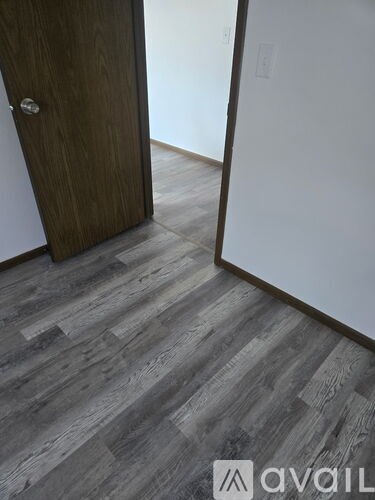 A room with a carpeted floor and a window with a white frame.