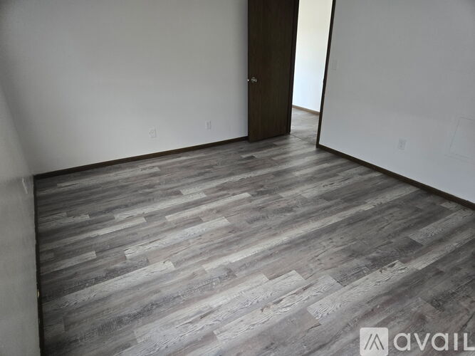 A room with a brown door and a carpeted floor.