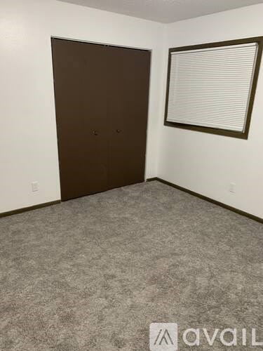 A room with a brown door and a carpeted floor.