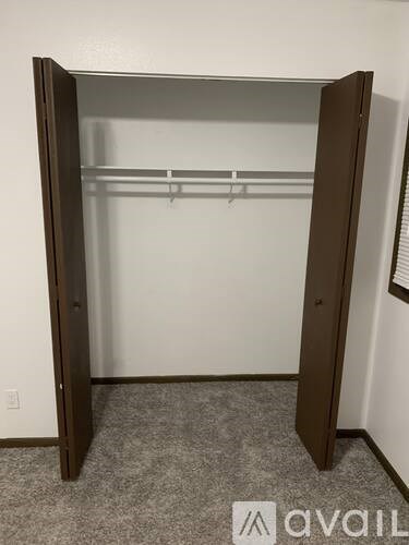 A large open closet with a grey carpeted floor.