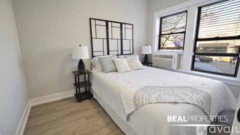 A bedroom with a large bed and a window overlooking a city street.