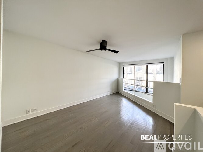 A spacious room with a ceiling fan and a window letting in natural light.