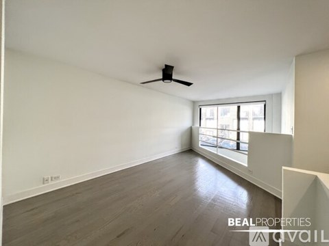 A spacious room with a ceiling fan and a window letting in natural light.