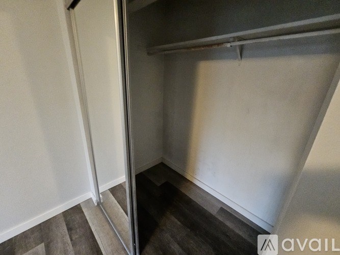 A hallway with a metal railing and a wooden floor.