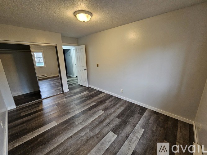 A room with wood flooring and a white door.
