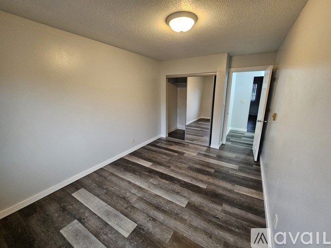 A hallway with a carpeted floor and a light on the ceiling.
