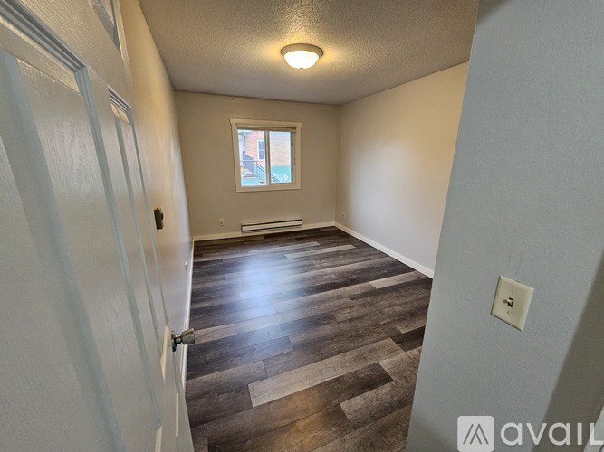 A room with wooden flooring and a window.