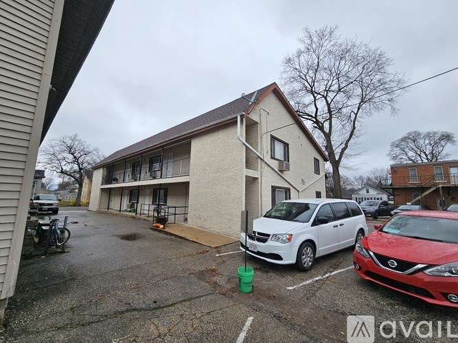 A white van is parked in a parking lot in front of a building.
