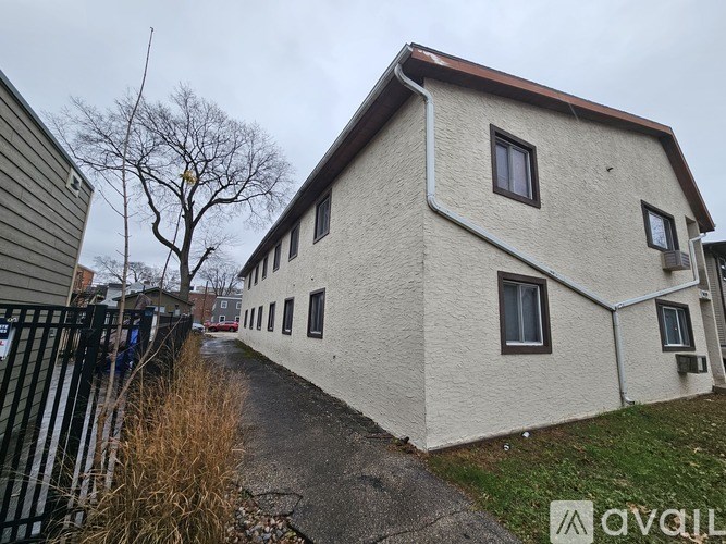 A house with a white exterior and a brown roof is shown.
