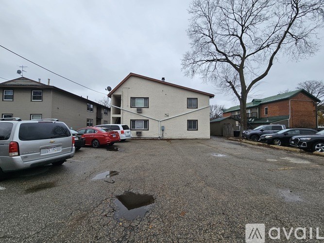 A parking lot with cars and a building in the background.