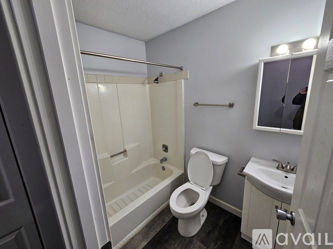 A bathroom with a toilet, sink, and bathtub.