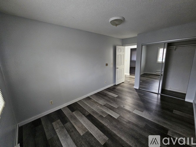 A room with wooden flooring and a white ceiling.