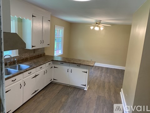 A kitchen with white cabinets and a wooden island.