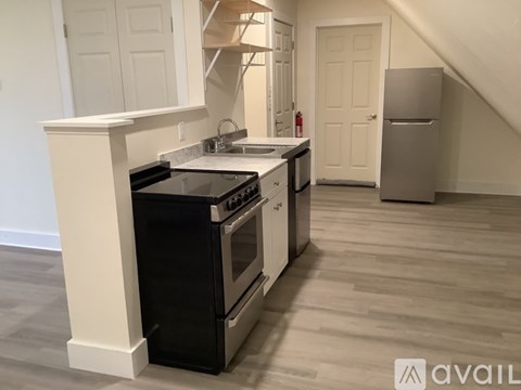 A kitchen with a black stove top oven and a white refrigerator.