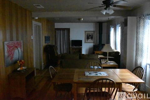 A dining room with a wooden table and chairs.