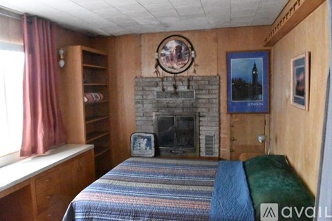 A bedroom with a fireplace and a bed.