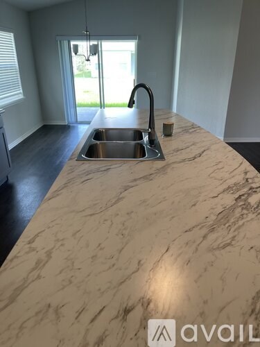 A kitchen counter with a sink and a faucet.