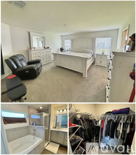 A bedroom with a black leather chair, a white bed, and a walk-in closet with clothes.