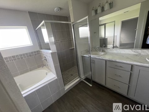 A bathroom with a white tub and a walk-in shower.