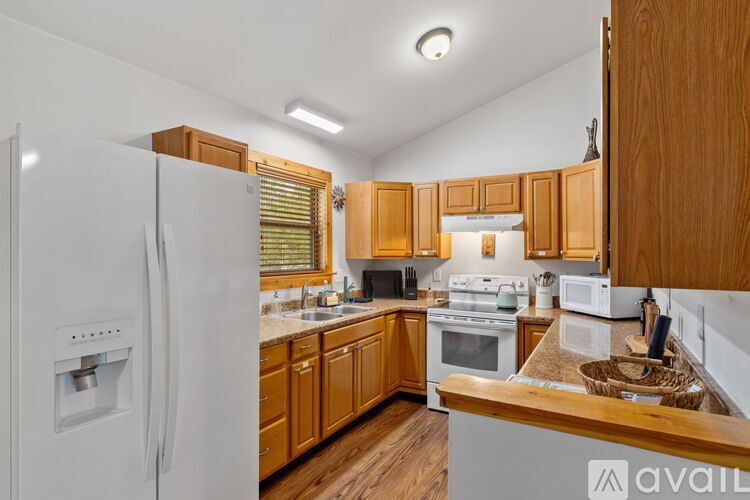 A kitchen with wooden cabinets and a white fridge.