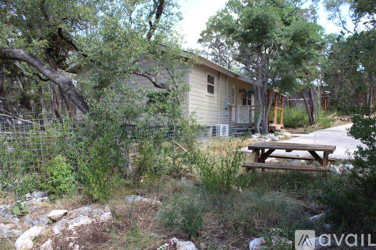 A house surrounded by trees and a picnic table.