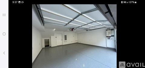 A spacious empty room with a high ceiling and fluorescent lighting.
