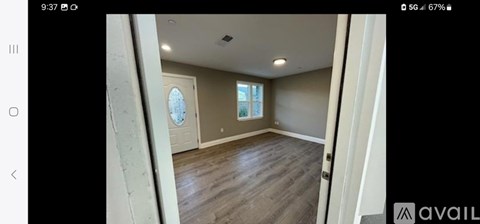 A room with wooden flooring and a window is available for rent or sale.