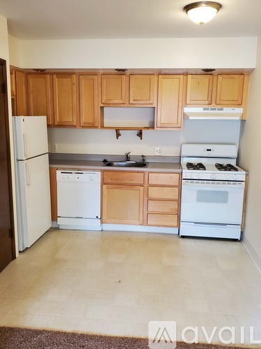 A kitchen with wooden cabinets and white appliances.