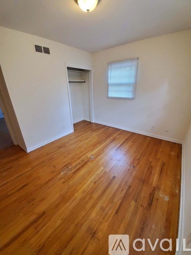 A room with wooden flooring and a window.