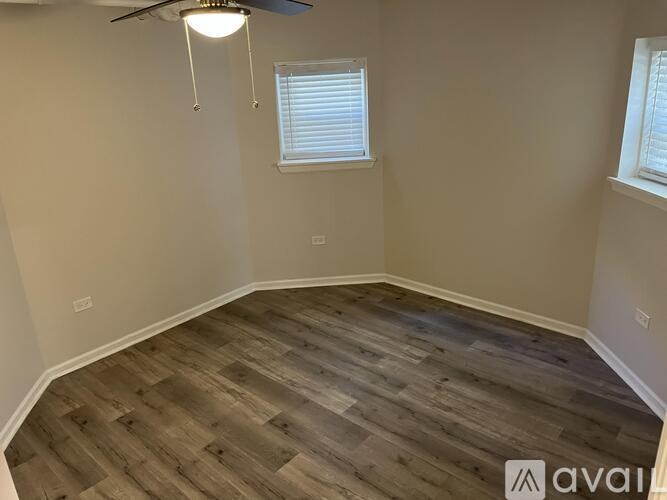 A room with wooden flooring and a ceiling fan.