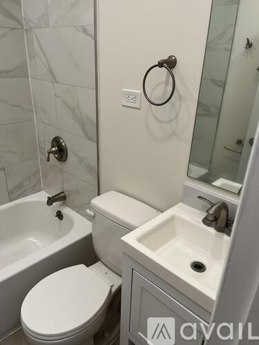 A white toilet sits next to a sink in a bathroom.