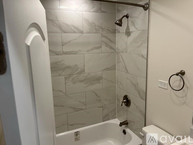 A bathroom with a white tub and a shower with a glass door.