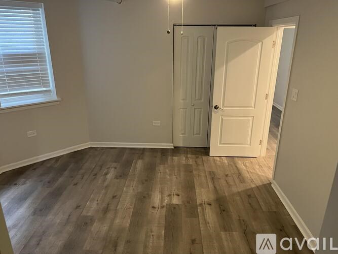 A room with wooden flooring and a white door.