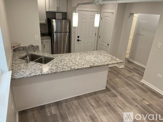 A kitchen with a granite countertop and a refrigerator.