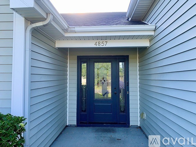 The front door of a house with the number 4857 on the wall above it.